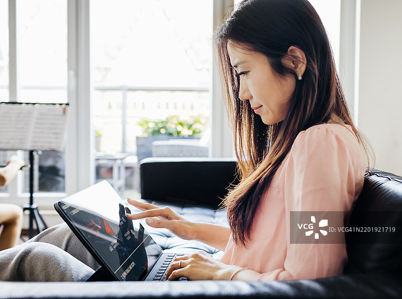 专注的女性在使用平板电脑工作图片素材