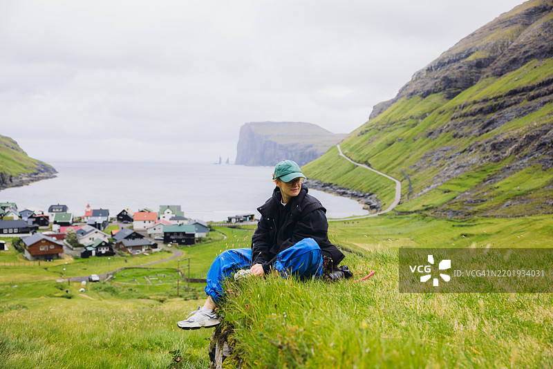 旅客欣赏着Tjornuvik村的观景点，享受田园诗般的山海美景图片素材