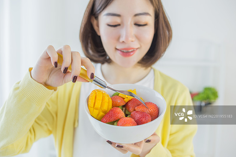女人在吃热带水果沙拉图片素材