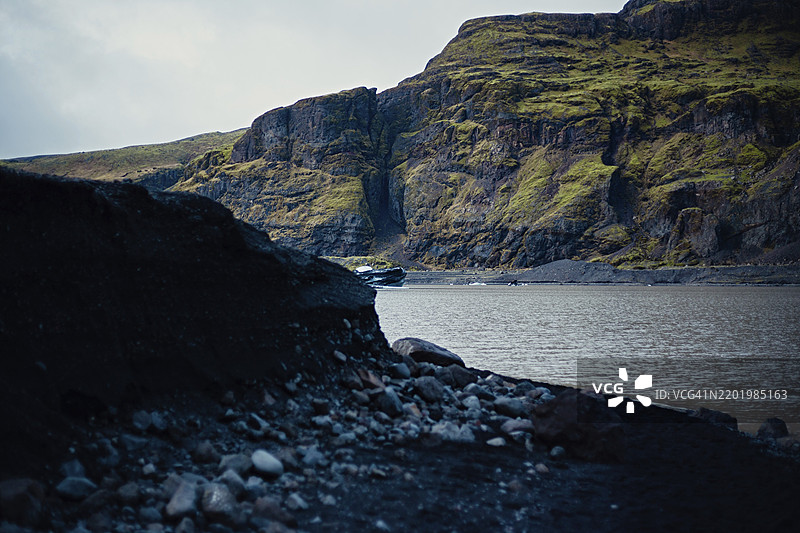 水边的崎岖悬崖，展示自然岩石形成、冰山、冰川、雪、冰岩、冰钻、冰川湖泊，展现大自然的美丽，冰岛，欧洲图片素材