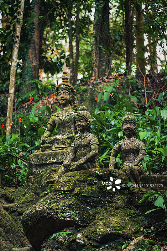 被郁郁葱葱的绿树环绕的石雕，人物，石像，纪念碑，塔尼姆魔法花园，纳穆昂乡，丛林，绿色，苏梅岛区，泰国，亚洲图片素材