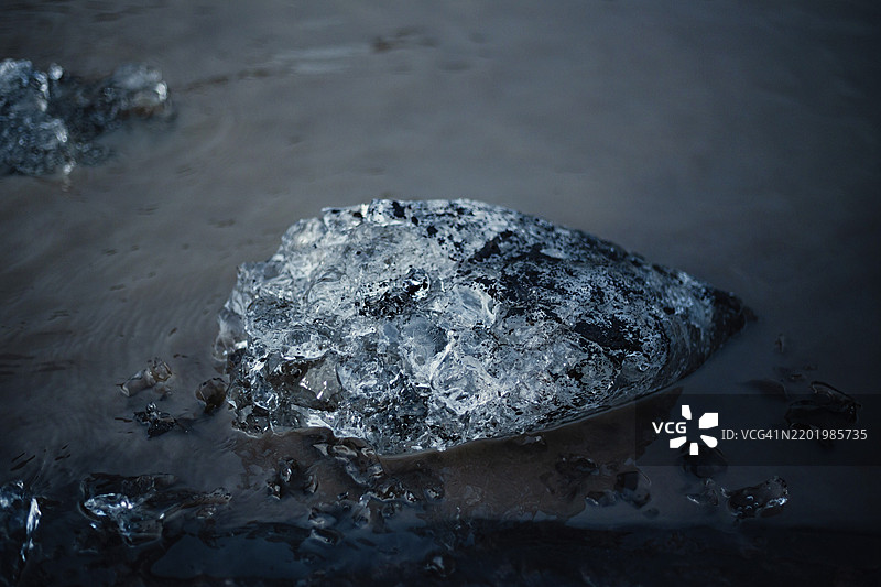 黑暗潮湿的冰块静静地漂浮在水面上，冰山，冰川，雪，冰岩，冰钻，冰川湖，自然，雪，冰岛，欧洲图片素材