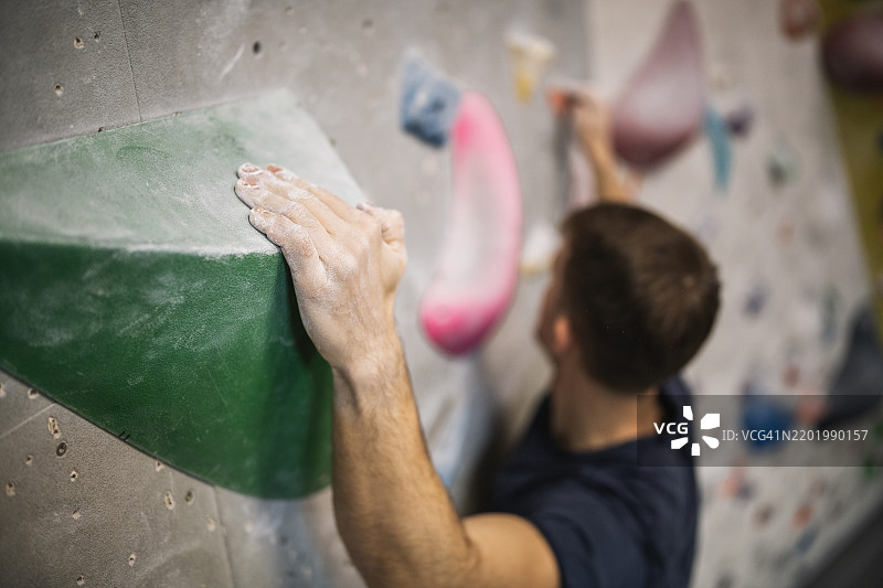 攀岩者在室内攀岩馆抓住人造抱石墙。图片素材