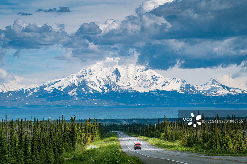 在阿拉斯加的空旷道路上行驶的汽车图片素材