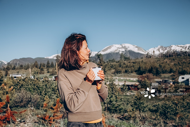 山间度假胜地，女人在美丽的阿尔卑斯山景中享受户外咖啡图片素材