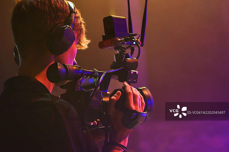 年轻的摄像师在拍摄现场活动 - 专业摄影师在电影或电视舞台上图片素材