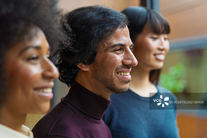 专业团队成员微笑着，展望未来，象征着职场团结与积极合作。图片素材