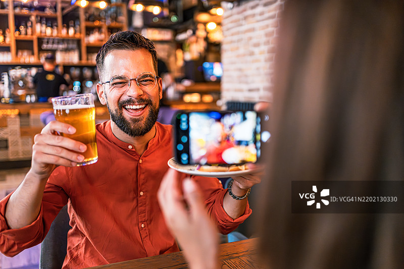 女人在餐厅给男朋友拍照图片素材