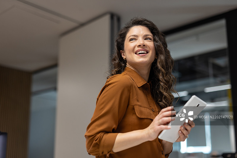 在现代办公室中使用数字平板电脑的女商人图片素材