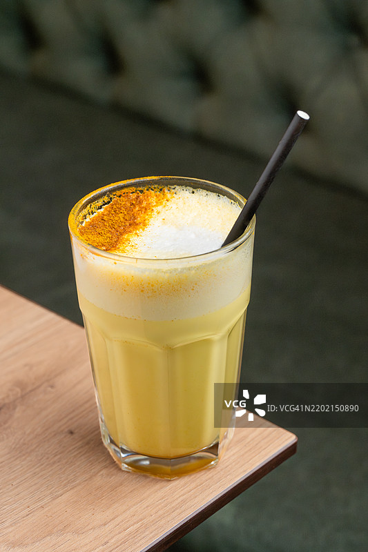 金色牛奶姜黄拿铁，配有泡沫牛奶和香料图片素材