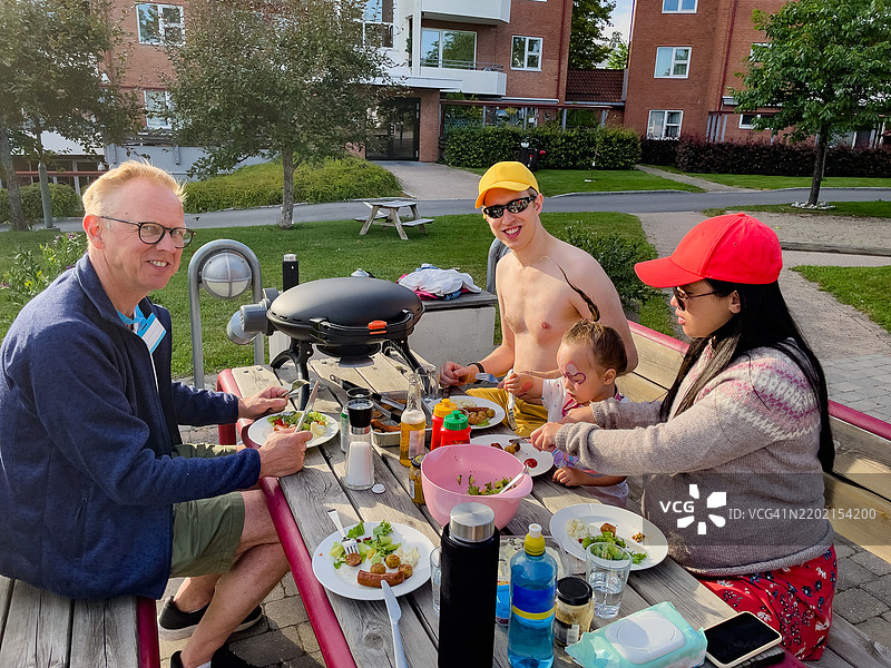 一个多种族家庭正在户外野餐。图片素材