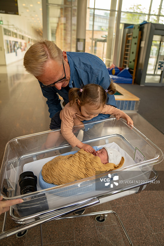 祖父和孙子在挪威奥斯陆大学医院见到了他们最新的家庭成员。图片素材