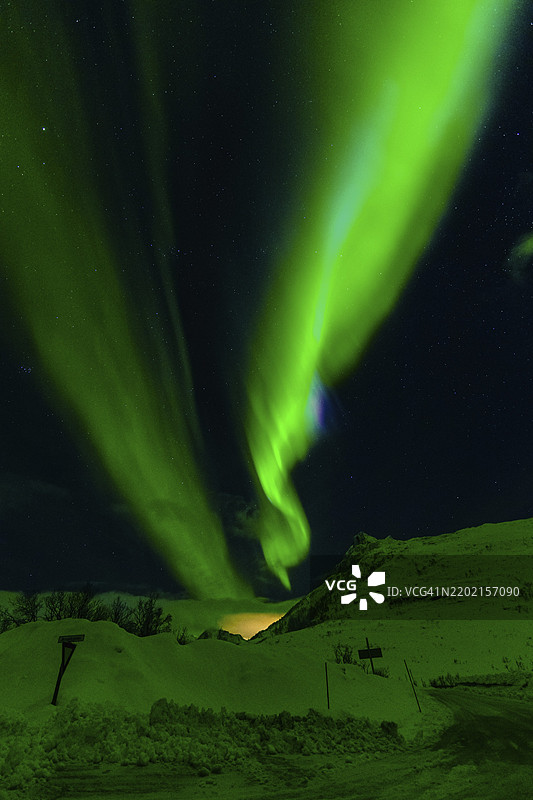 闪烁的绿色极光在星空下的雪丘上延展，北极光，极光，绿色光芒，夜晚，现象，魔幻光影，自然，天空，夜晚，挪威，冰岛，欧洲图片素材