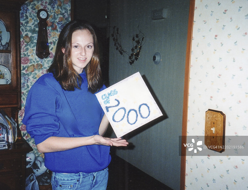 2000年代的青少年手持毕业帽，Y2K年份2000的复古高中生，2000届毕业班图片素材