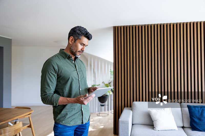 男子使用数字平板控制智能家居图片素材