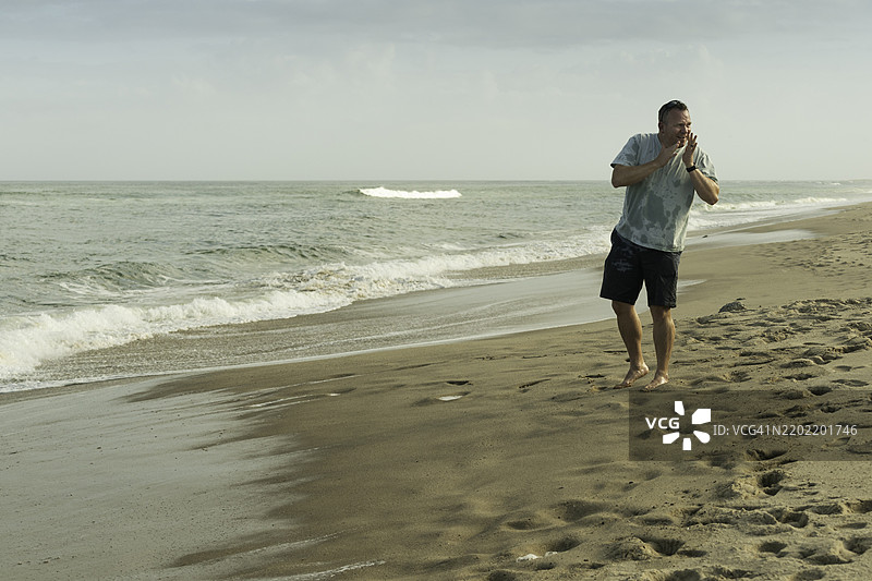 在海滩上呼喊某人的男人，科德角图片素材
