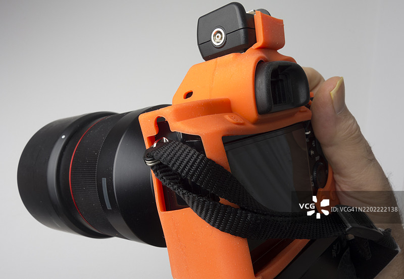 摄影师手持不合身的保护盔甲的单反数码相机图片素材