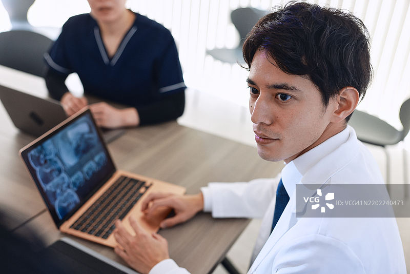 一位男性亚洲医生在与护士开会时专注倾听的特写镜头图片素材