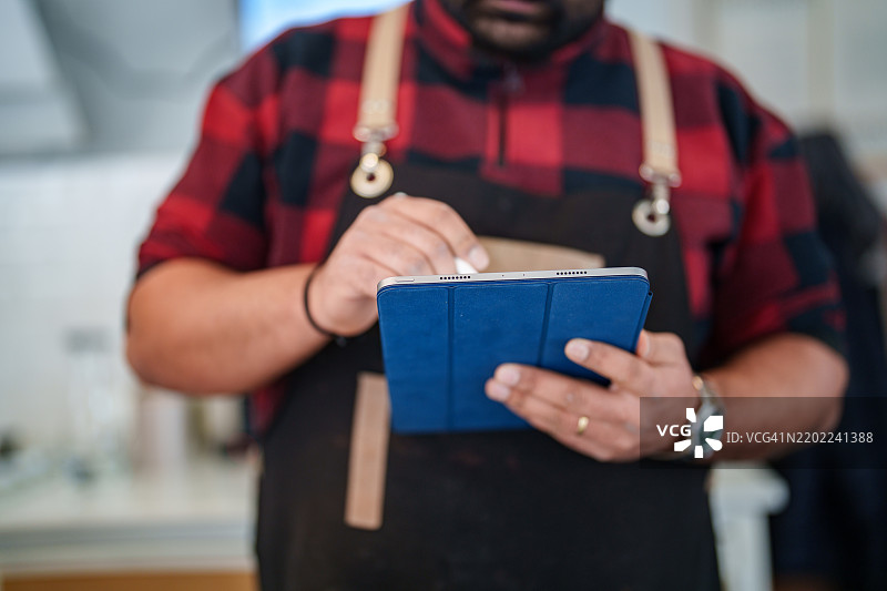 咖啡师使用数字平板电脑的特写镜头。图片素材