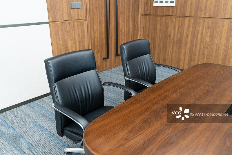 会议室内部，配有黑色皮椅和木桌图片素材