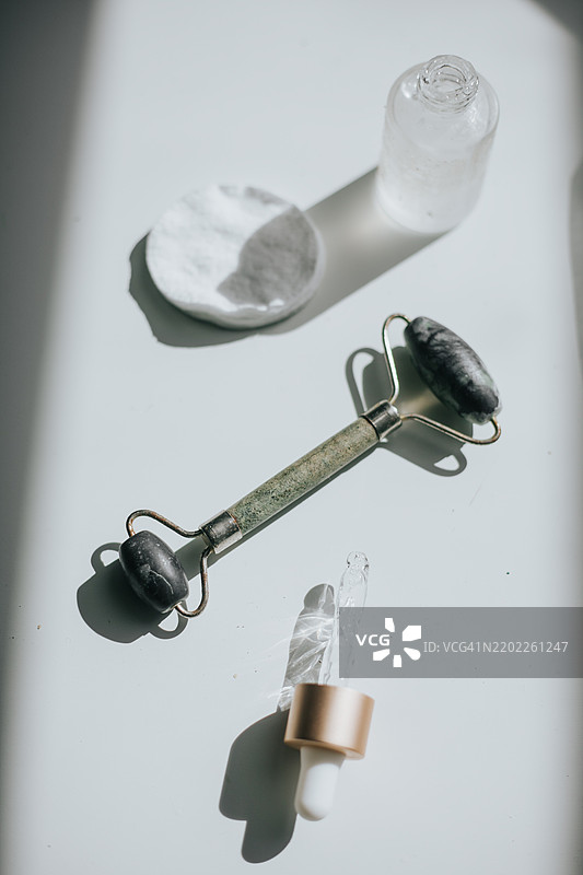 双头玉石面部按摩滚轮和护肤精华图片素材