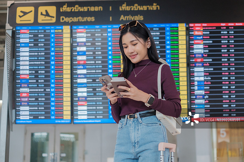 亚洲女性在等待飞机并查看航班信息图片素材