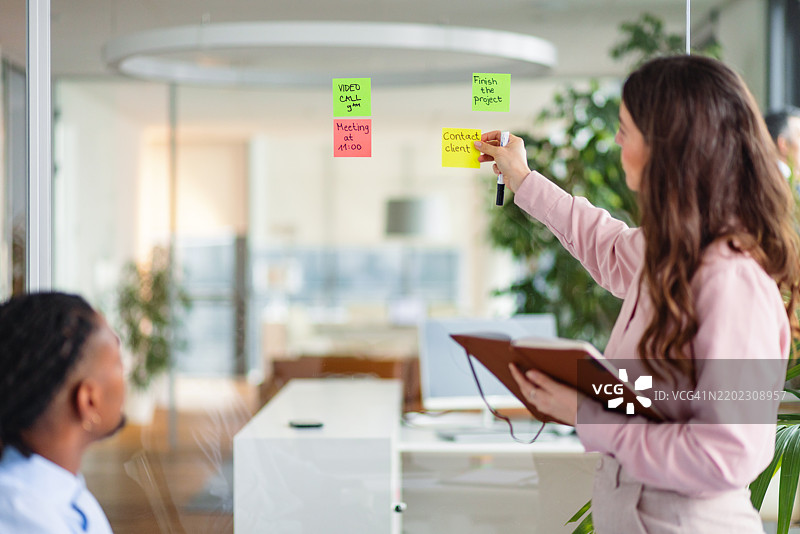 团队在现代办公室中使用便利贴进行协作图片素材