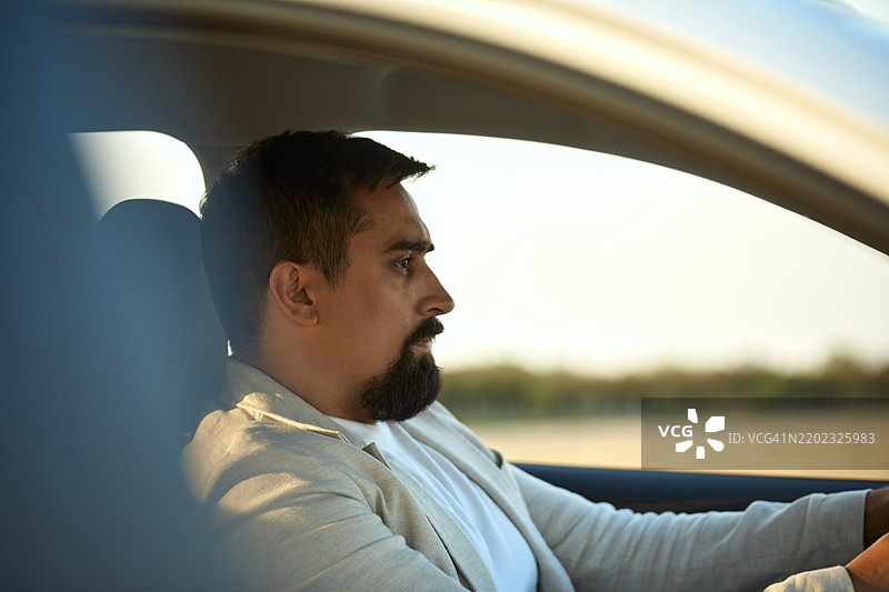 透过窗户看到的留胡子的男人驾驶汽车图片素材