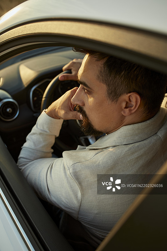 坐在车里的沉思男子，手托着下巴图片素材