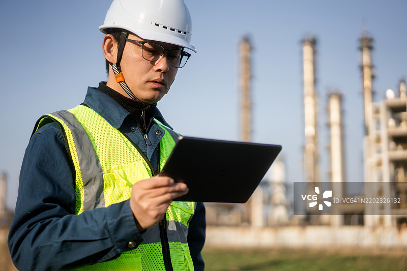 亚洲工程师在石油工厂使用数字平板电脑工作图片素材