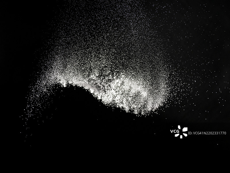 向下撒的厨房盐粒为食物调味。图片素材