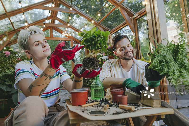 农民在温室附近照料植物图片素材