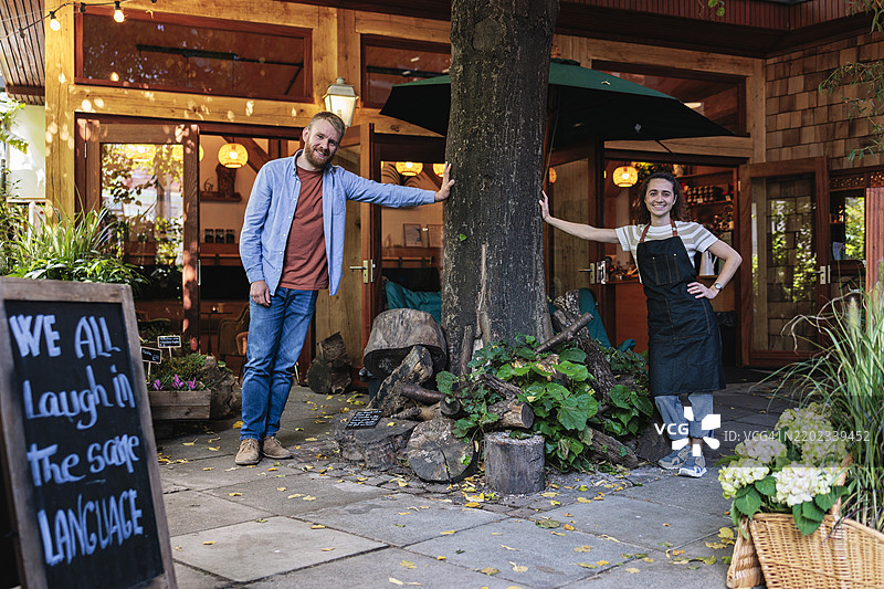 多种族咖啡馆老板站在咖啡店外的树旁图片素材