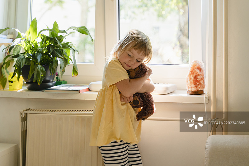 女孩在家中拥抱泰迪熊图片素材