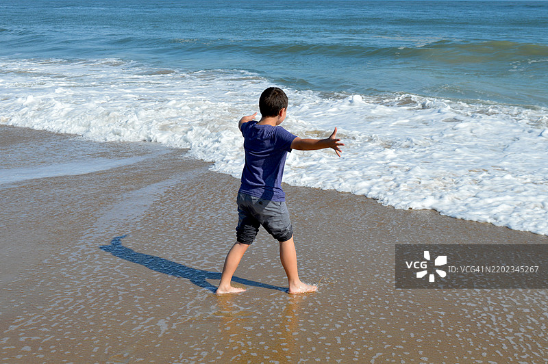 8岁男孩在海滩上玩耍图片素材