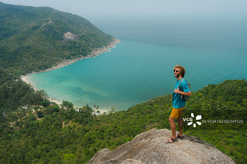 男子在泰国的科潘岛欣赏宁静的海滩图片素材