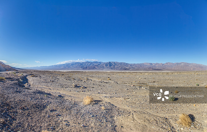 广阔的沙漠景观在明亮的蓝天下，远处有山脉，炉子溪，加利福尼亚州，美国图片素材