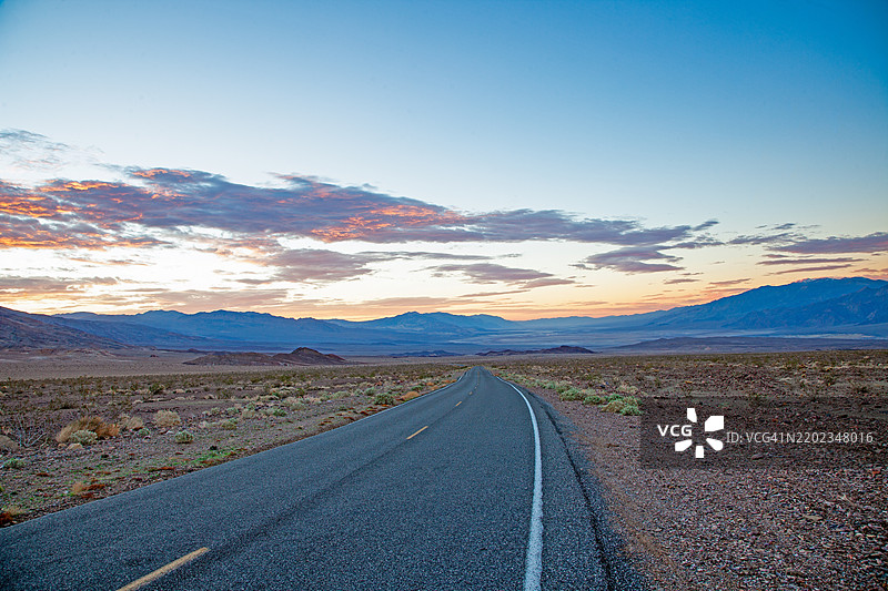 日落时分的风景沙漠公路，五彩斑斓的云彩和山脉背景，炉子溪，加利福尼亚州，美国图片素材