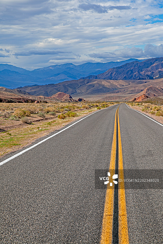 一条漫长的沙漠公路消失在亚利桑那州、加利福尼亚州的熔炉溪和美国的远处山脉中图片素材