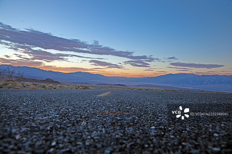 日落时分的风景沙漠公路，五彩斑斓的云彩和山脉背景，炉子溪，加利福尼亚州，美国图片素材