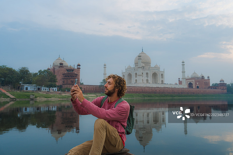在印度泰姬陵的船上用智能手机拍照的男子图片素材