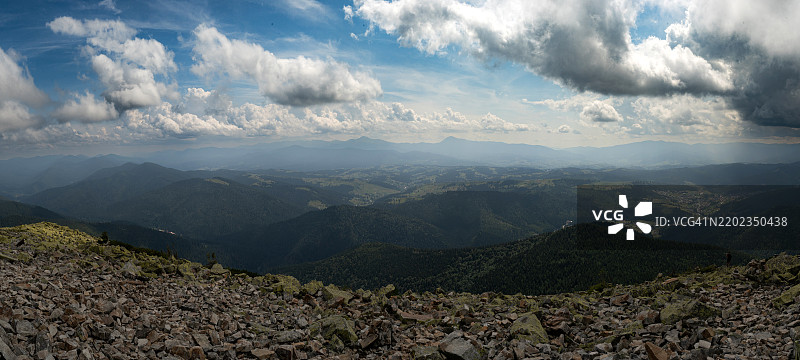 在明亮的蓝天和点缀着云朵的山脉地平线下，令人惊叹的景色图片素材