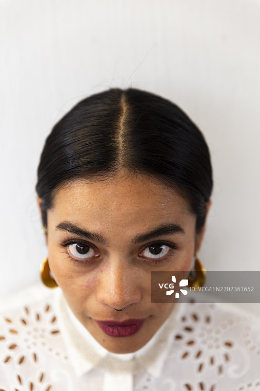 穿着白衬衫的女人站在墙前图片素材