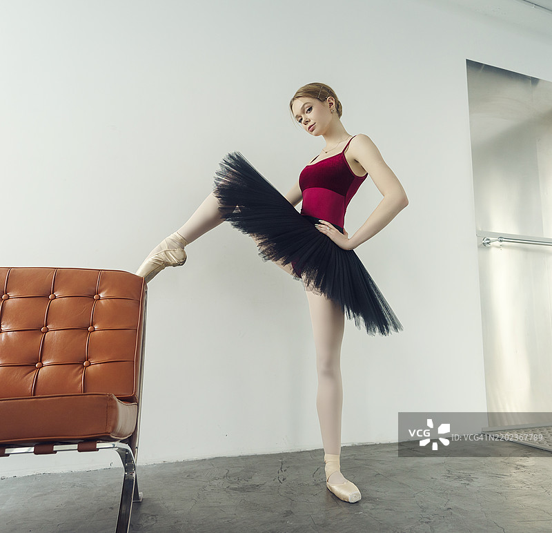 年轻的芭蕾舞者穿着舞裙和尖头鞋，坐在扶手椅上，位于俄罗斯西伯利亚的诺沃西比尔斯克。图片素材