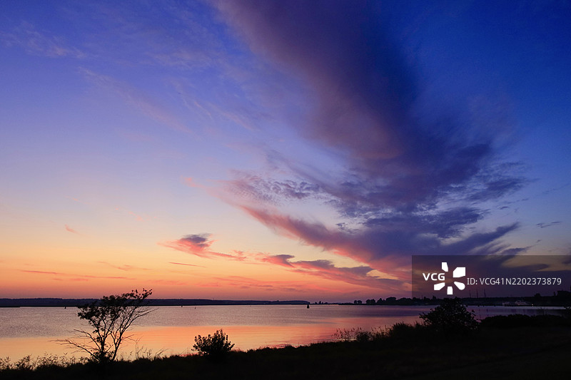 德国乌瑟多姆的佩内明德风景如画的日落，天空绚丽多彩，水面宁静。图片素材