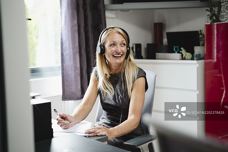 微笑的女商人在家中办公室工作图片素材