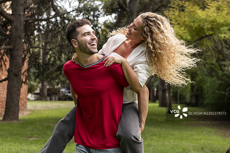 快乐的男朋友在公园里背着女朋友图片素材
