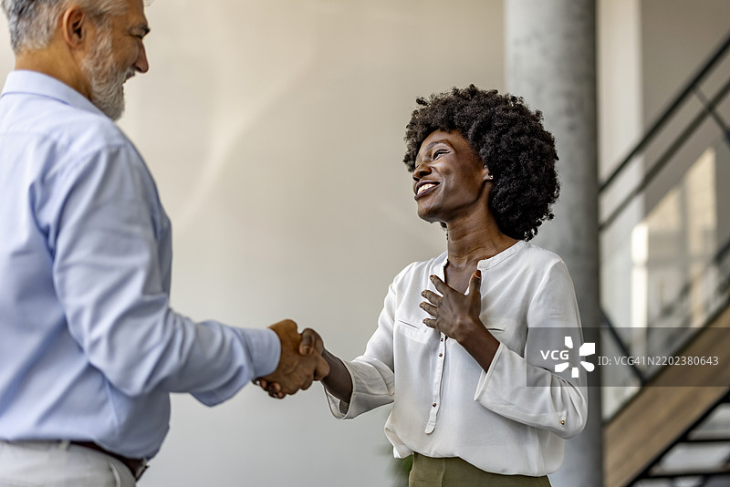 多元化同事在现代办公室环境中握手图片素材