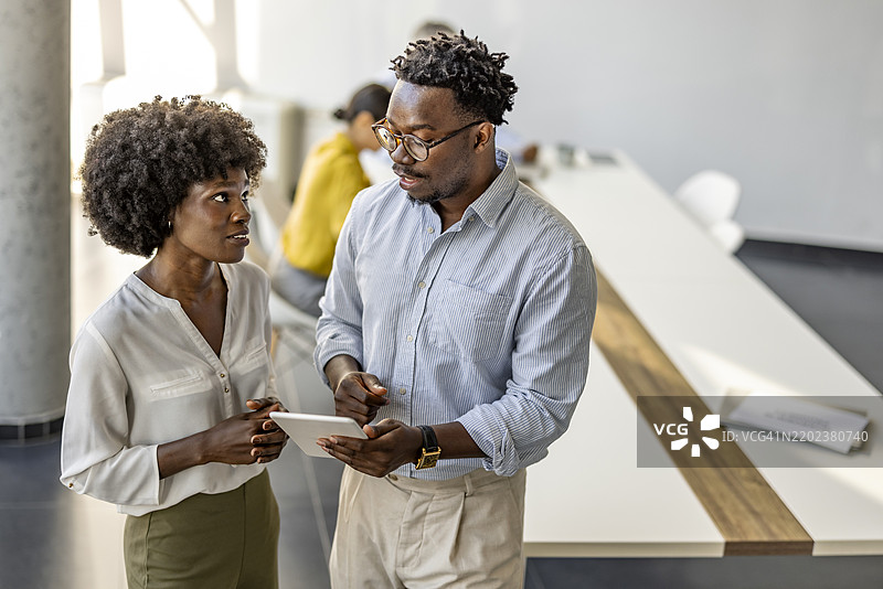 同事之间使用数字平板进行专业讨论图片素材