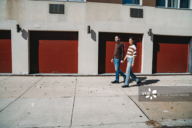 一对时尚情侣在布什维克的人行道上散步图片素材